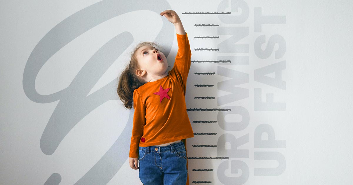 Little Girl Growing Measuring Against Wall